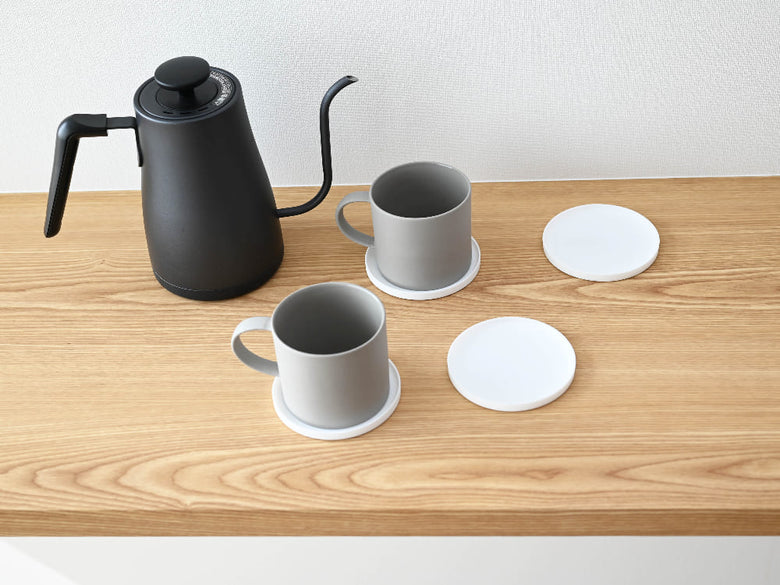 シリコーン製の【tower/タワー】立体コースター、角型と丸型がテーブル上に整然と並べられている様子