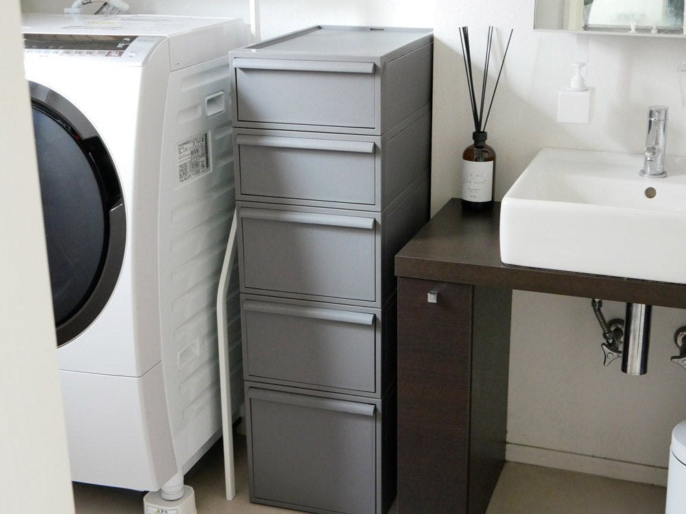 木製床に置かれたグレーの引き出し付きクローゼット