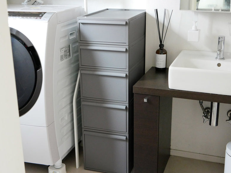 木製床に置かれたグレーの引き出し付きクローゼット