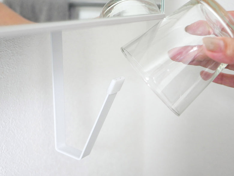 プラスチック、ガラス、銀の調理器具が収納された洗面戸棚下ホルダー